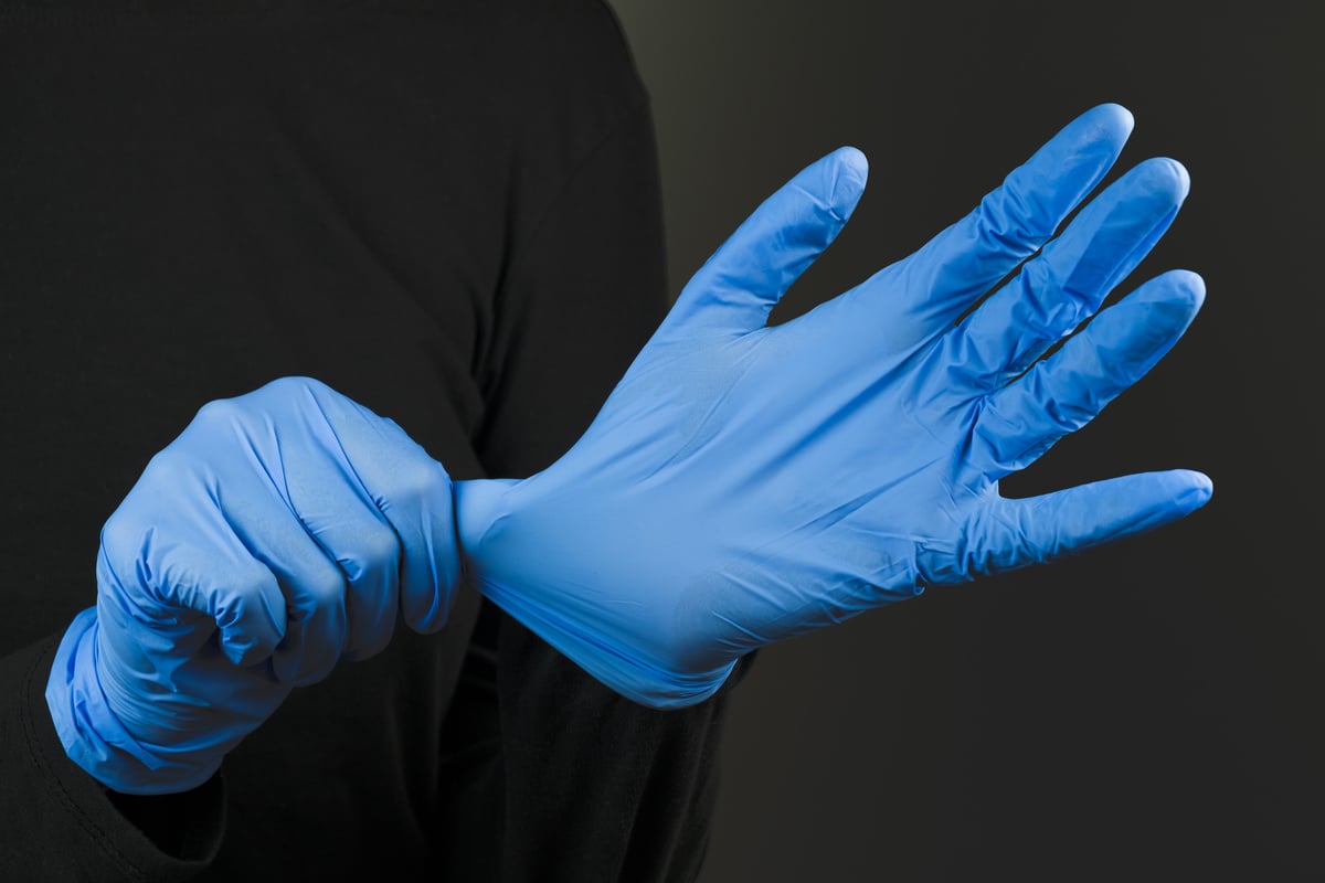 Person Putting Surgical Gloves on 